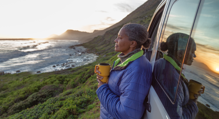 woman looking into distance leaning on van